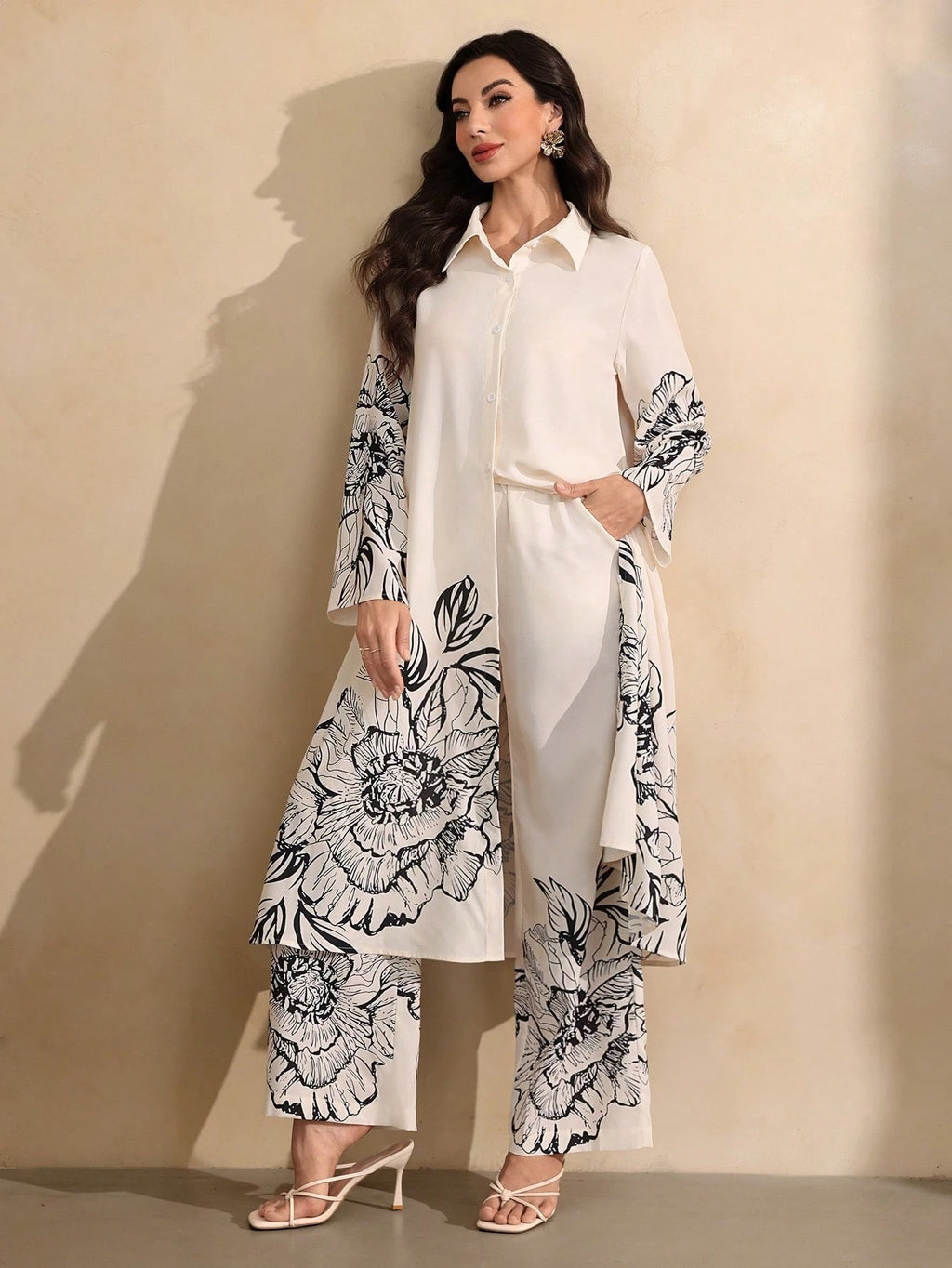 Woman wearing a white outfit with black floral patterns against a beige background