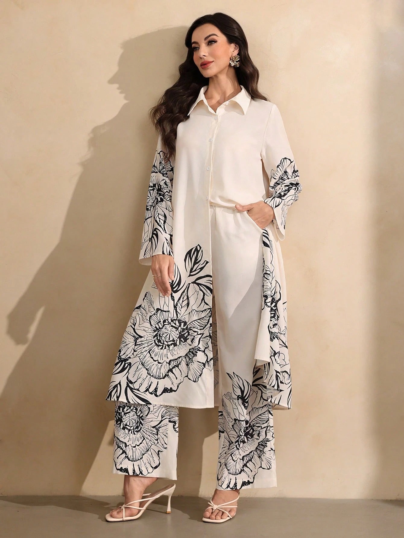 Woman wearing a white outfit with black floral patterns against a beige background
